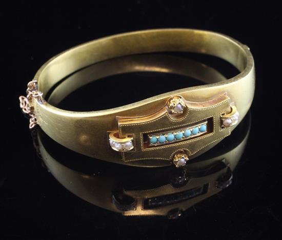 A late 19th/early 20th century Austro-Hungarian 14ct gold, turquoise and seed pearl set hinged bangle, gross 19 grams.